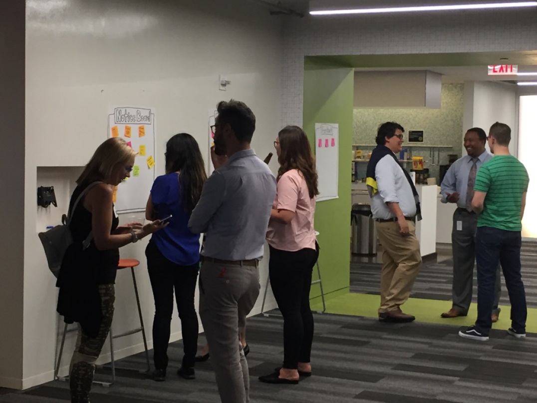 Service Designers huddle around the Notice Board and hang out at Deloitte Digital.